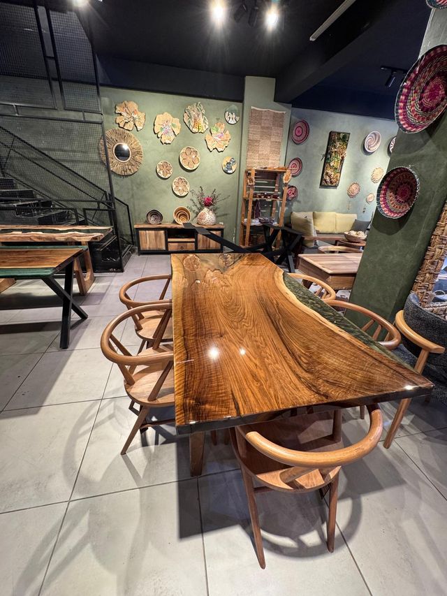 Showroom içinde yan yana duran masif ve epoksili yemek masaları